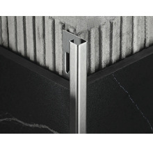 Närbild av en metallisk kakelprofil i ett hörn mellan två kakelplattor