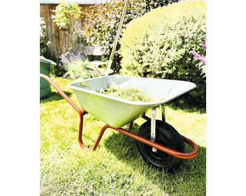 Skottkärra med trädgårdsavfall i trädgården