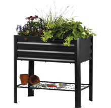 Upphöjd rabatt med växter, förvaringsutrymme, planteringskärl och trädgårdsredskap.