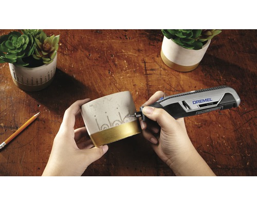 Scen av gravering av en blomkruka med ett Dremel Lite-verktyg på en träyta.