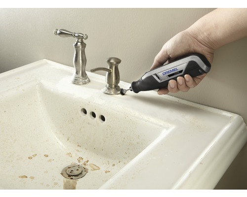 Dremel logotyp vid rengöring av ett handfat med ett Dremel Lite multifunktionsverktyg.