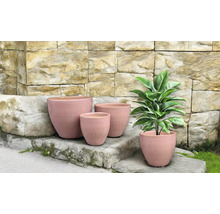 Blomkrukor i olika storlekar framför en stenmur