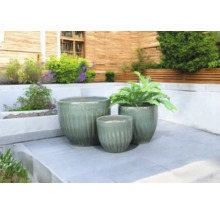 Tre keramiska blomkrukor på en terrass