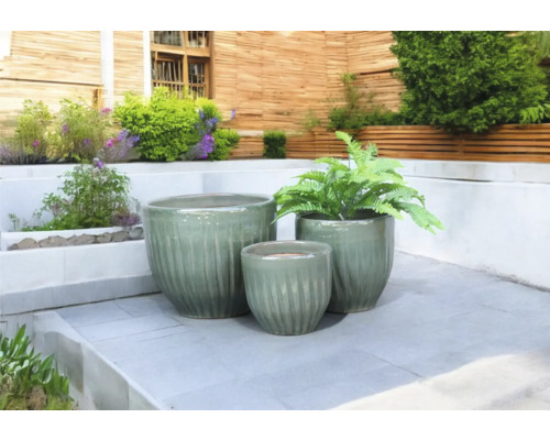 Tre keramiska blomkrukor på en terrass