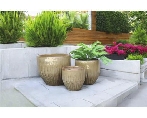 Scen med tre keramiska blomkrukor i trädgården