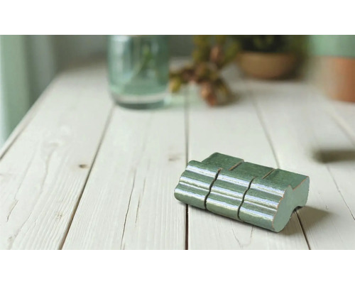 Gröna mosaikplattor på ett träbord