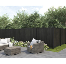 Trädgårdsscen med mörk insynsskydd och sittgrupp på en terrass