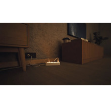 Grenuttag med anslutna strömkablar i ett vardagsrum.