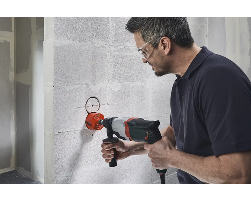 Man borrar hål i väggen med hålsåg