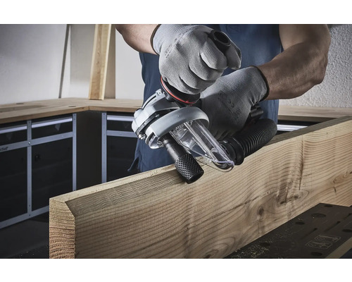 En operatör använder en spårfräs på en träplanka.