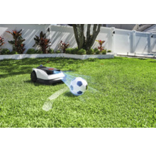 Robotgräsklippare på gräsmatta med fotboll