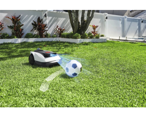 Robotgräsklippare på gräsmatta med fotboll