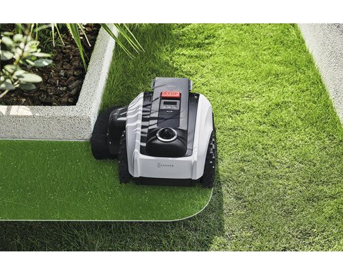 Robotgräsklippare som underhåller en gräsmatta i en trädgård.