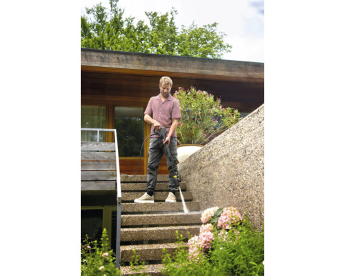 Man rengör utomhustrappa med högtryckstvätt.