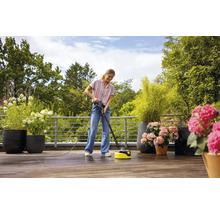 Kvinna rengör terrass med en terrasstvätt.