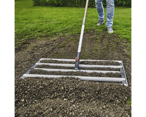 Jordbearbetning med en avjämningsskena i trädgården.