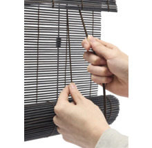 Person använder en bambujalusie med dragsko.