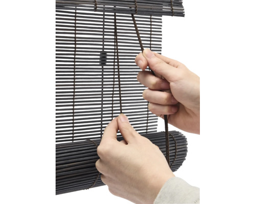 Person använder en bambujalusie med dragsko.