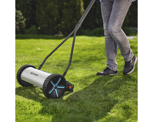 Handgräsklippare i bruk på en gräsmatta