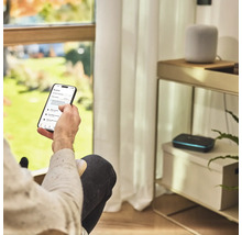 En person använder en trädgårdsbevattningsapp på en smartphone