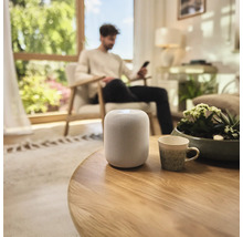 Inredning av ett vardagsrum med en smart högtalare på ett bord.