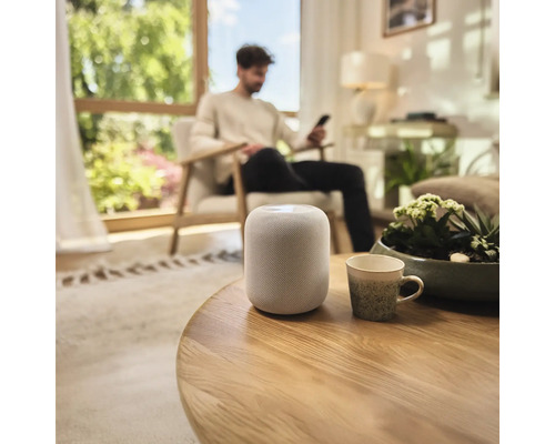 Inredning av ett vardagsrum med en smart högtalare på ett bord.