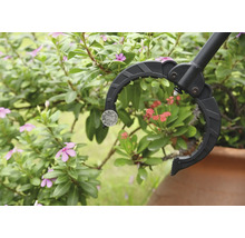 Griptång för att plocka upp ett mynt framför växter