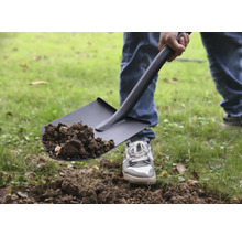 Person som skyfflar jord med en spade.