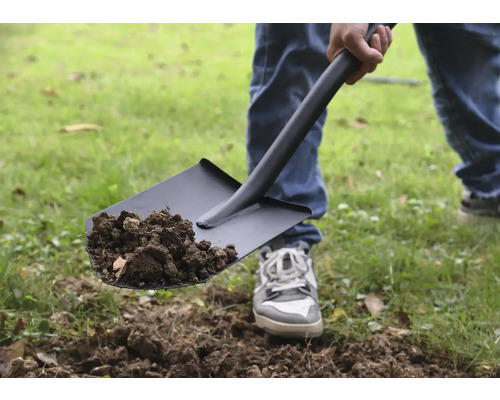 Person som skyfflar jord med en spade.