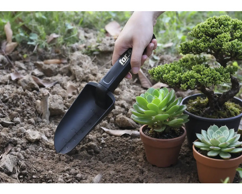 Trädgårdsspade med markeringar som används bredvid växter i krukor.