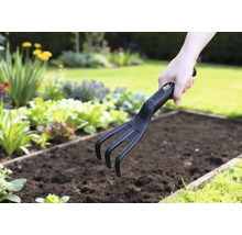 Trädgårdskultivator som används i en grönsaksbädd.