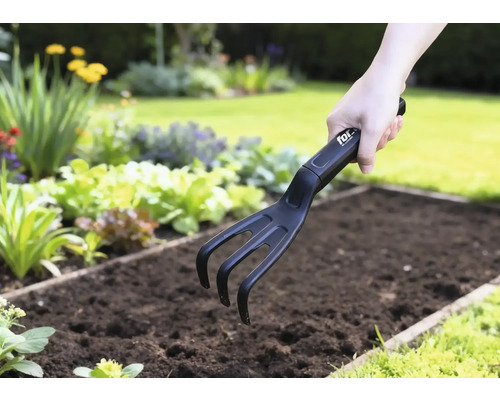 Trädgårdskultivator som används i en grönsaksbädd.