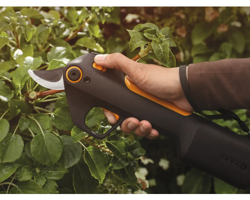 Batteridriven trädgårdssax i bruk på en växt