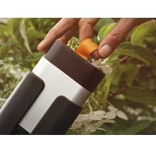 Person drar i ett orange band på ett trädgårdsredskap.