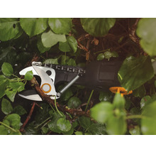 Batteridriven grensax klipper gren mellan gröna blad