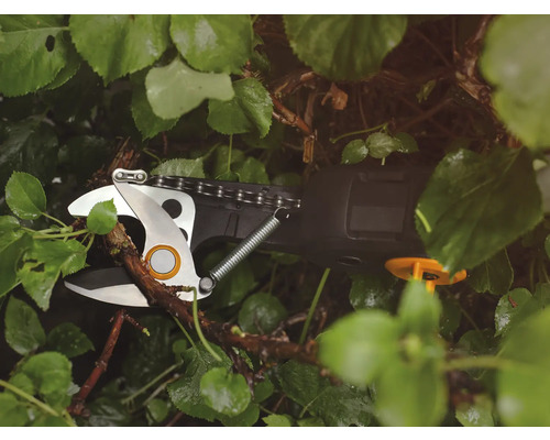 Batteridriven grensax klipper gren mellan gröna blad