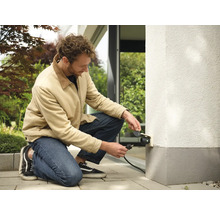 Man ansluter ett utomhusuttag till husväggen