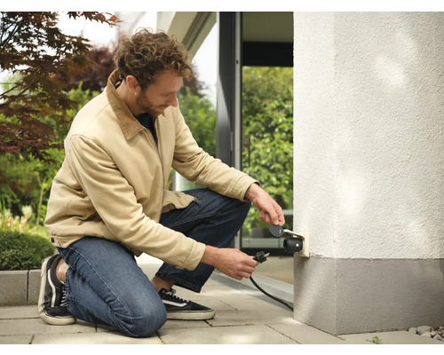 Man ansluter ett utomhusuttag till husväggen