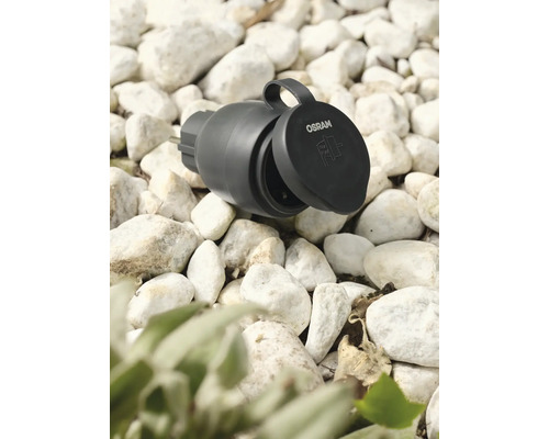 Osram Logo. Trädgårdsuttag med öppet lock på grus.