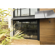 Utsida av ett hus med solpaneler och garageport i glas