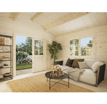 Interiör av ett ljust trädgårdshus med soffa, bord och hyllor