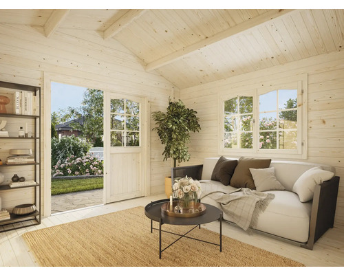 Interiör av ett ljust trädgårdshus med soffa, bord och hyllor