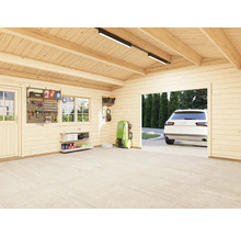 Interiör av ett garage med träpanel, verktygsvägg och en parkerad bil i bakgrunden