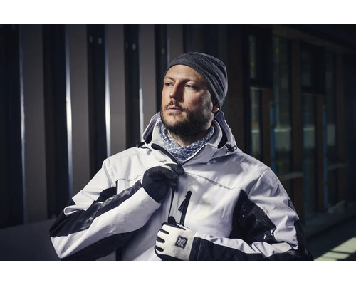 Man i arbetsjacka med huva, mössa och handskar