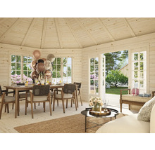 Ljust trähus med matbord, stolar, dekoration och öppna fönster mot trädgården.