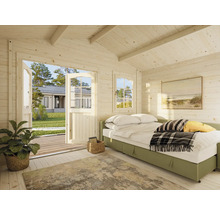 Ljust rum med träväggar, säng och öppen dörr till trädgården