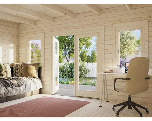 Interiör av ett trädgårdshus i trä med säng, skrivbord och utsikt över trädgården