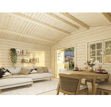 Ljust trärum med soffa, hyllor, matbord och fönster för en mysig atmosfär.