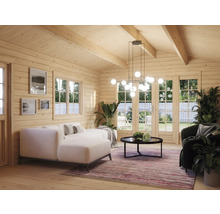 Ljus interiör i ett trähus med soffa, fåtölj, bord och pendellampa