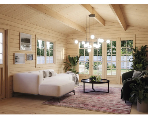 Ljus interiör i ett trähus med soffa, fåtölj, bord och pendellampa